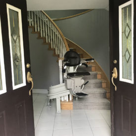 Stairlift waits at the bottom of the stairs for use.